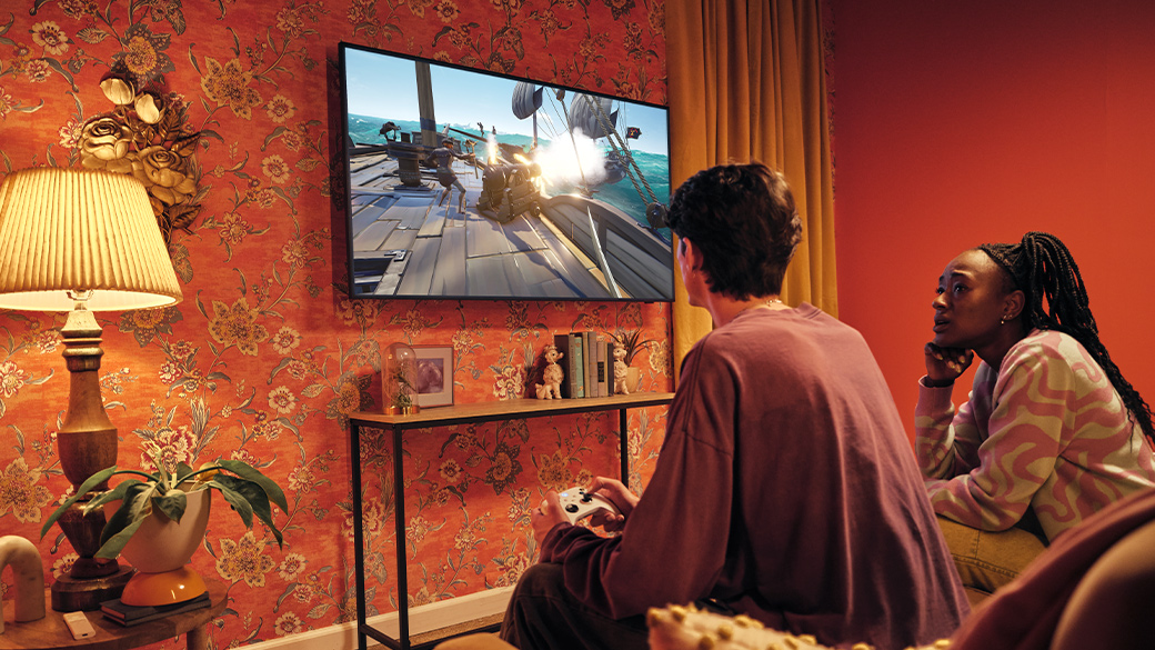 Két ember egy nappaliban Xbox-ozik egy Samsung okos tévén